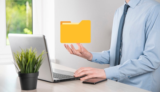 Geschäftsmann hält Ordnersymbol. Dokumentenverwaltungssystem oder DMS-Setup von IT-Berater mit modernem Computer suchen nach Verwaltungsinformationen und Unternehmensdateien. Geschäftsabwicklung,