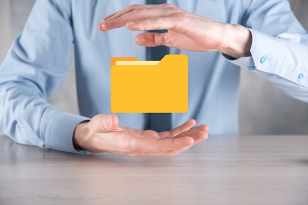 Geschäftsmann hält Ordnersymbol. Dokumentenverwaltungssystem oder DMS-Setup von IT-Berater mit modernem Computer suchen nach Verwaltungsinformationen und Unternehmensdateien. Geschäftsabwicklung,