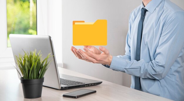 Geschäftsmann hält Ordnersymbol. Dokumentenverwaltungssystem oder DMS-Setup von IT-Berater mit modernem Computer suchen nach Verwaltungsinformationen und Unternehmensdateien. Geschäftsabwicklung,