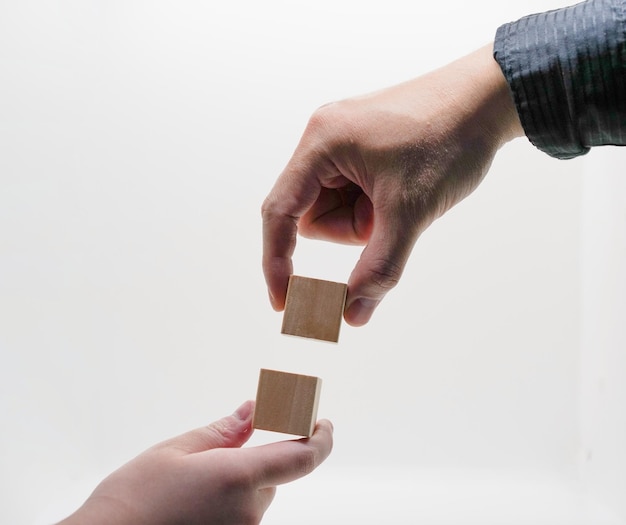 Foto geschäftsmann hält puzzleschild holzwürfel verbinden sich für unternehmenspartner und teamarbeit im unternehmenskonzept