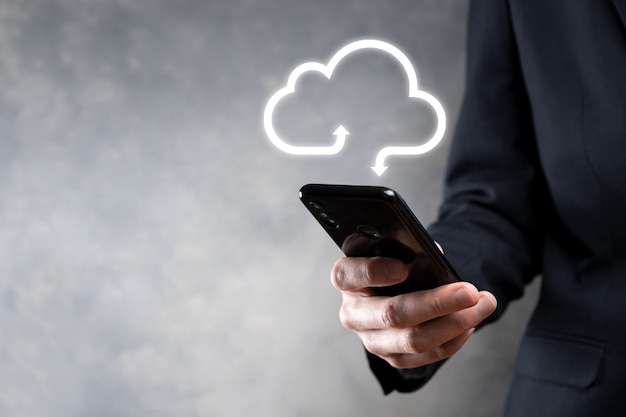 Geschäftsmann halten Cloud-Symbol. Cloud-Computing-Konzept - Smartphone mit Cloud verbinden. Computernetzwerkinformationstechnologe mit Smartphone. Großes Datenkonzept.