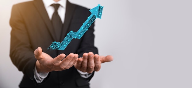 Geschäftsmann halten Diagramm, Pfeil des positiven Wachstumssymbols. Zeigen auf kreatives Geschäftsdiagramm mit Aufwärtspfeilen. Finanzielles, Geschäftswachstumskonzept. Niedriges Polygonal. Erhöhter Umsatz oder Wertsteigerung