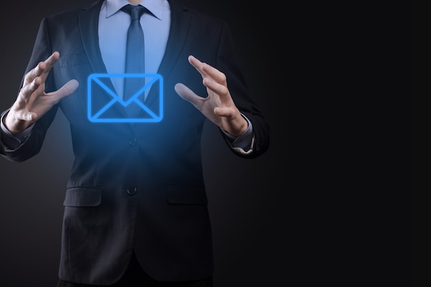 Geschäftsmann Hand mit E-Mail-Symbol, kontaktieren Sie uns per Newsletter-E-Mail und schützen Sie Ihre persönlichen Daten vor Spam-Mail. Kundenservice-Callcenter kontaktieren Sie uns Konzept