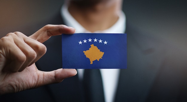 Geschäftsmann Holding Card der Kosovo-Flagge