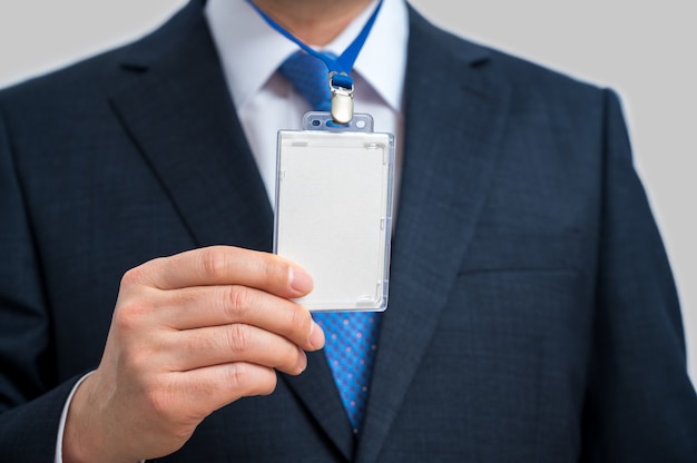 Foto geschäftsmann im anzug, der ein leeres id-etikett oder eine visitenkarte auf einem schlüsselband bei einer ausstellung oder konferenz trägt.