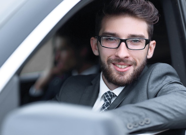 Geschäftsmann im Anzug, der sein luxuriöses Auto fährt