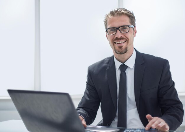 Geschäftsmann im Büro, das am Laptop arbeitet