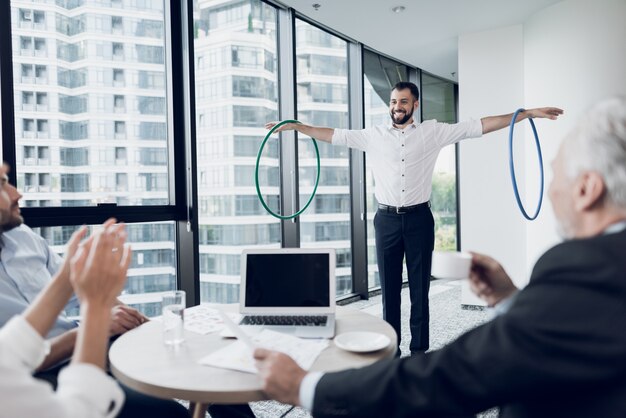 Geschäftsmann im Büro dreht Hula-Hoop.