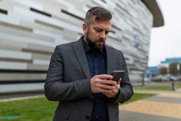 Geschäftsmann im Business-Anzug liest Nachrichten auf dem Handy