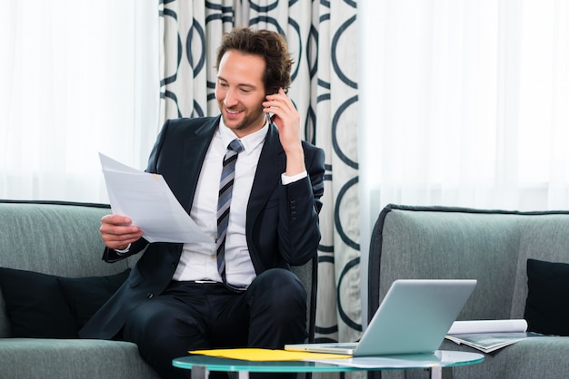 Geschäftsmann im Business Hotel ist am Telefon