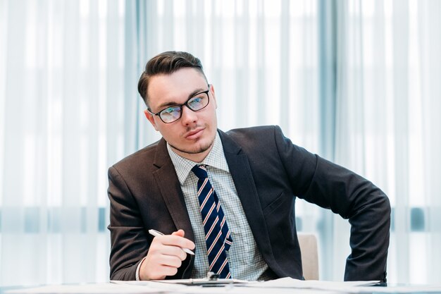 Geschäftsmann im intelligenten Anzug, der im Büro arbeitet