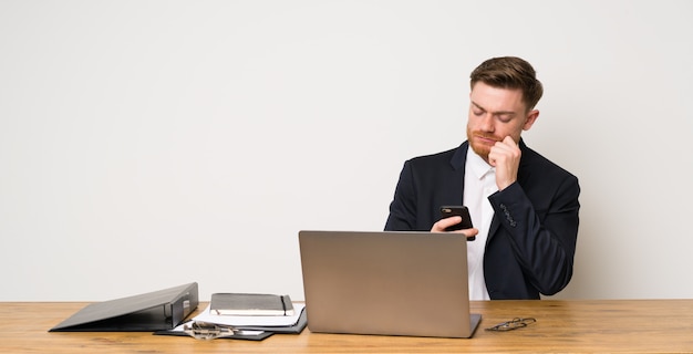 Geschäftsmann in einem Büro eine Mitteilung denkend und sendend