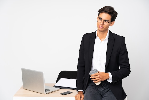 Geschäftsmann in seinem Büro über der weißen Wand, die zur Seite steht und schaut