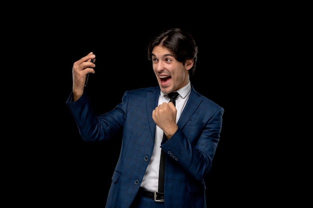 Geschäftsmann, junger, süßer, gutaussehender Mann im dunkelblauen Anzug mit Krawatte, der über Videoanruf spricht