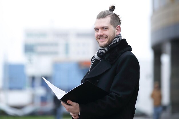 Foto geschäftsmann liest dokumente, die auf einer stadtstraße stehen