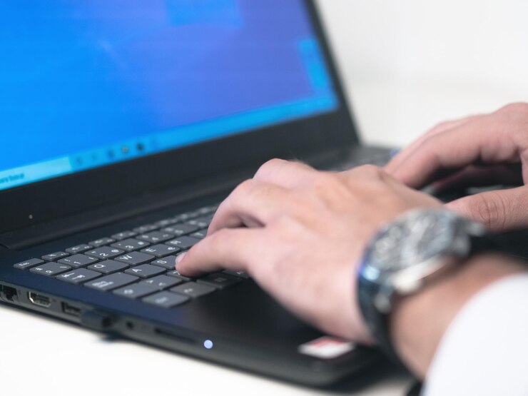 Geschäftsmann liest Online-Dokumente auf Laptop-Bildschirm mit Lupenkonzept zur Analyse einer Finanzierungsvereinbarung oder eines Rechtsvertrags