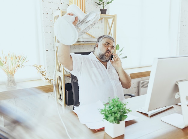 Geschäftsmann, Manager, der sich im Büro heiß fühlt