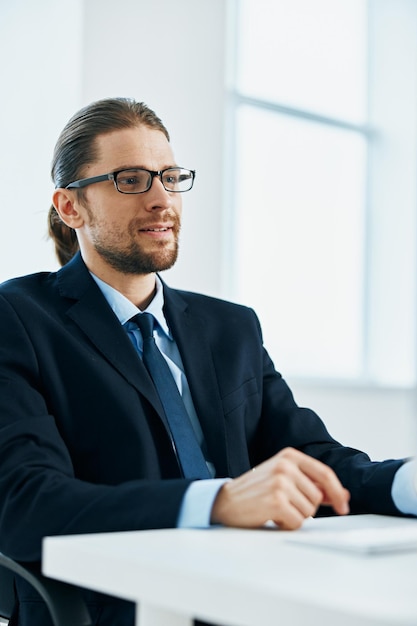 Geschäftsmann mit Brille und Anzug arbeitet am Computer im Büro, Foto in hoher Qualität