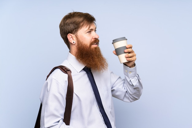 Geschäftsmann mit dem langen Bart, der Kaffee hält, um über lokalisiert wegzunehmen