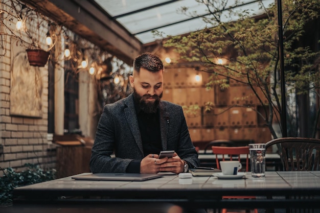 Geschäftsmann mit einem Smartphone in einem Café