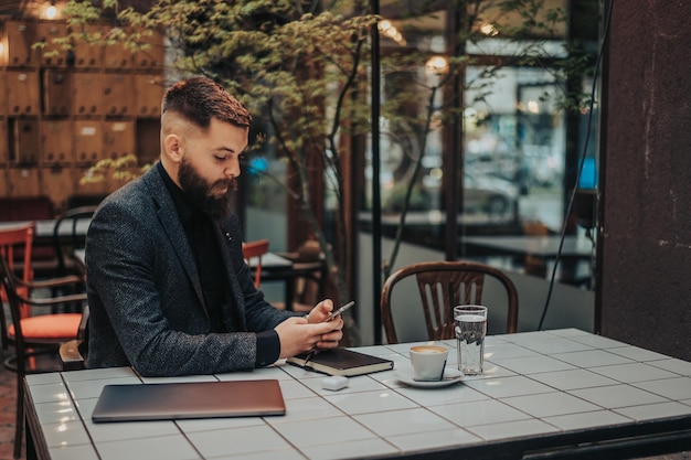 Geschäftsmann mit einem Smartphone in einem Café