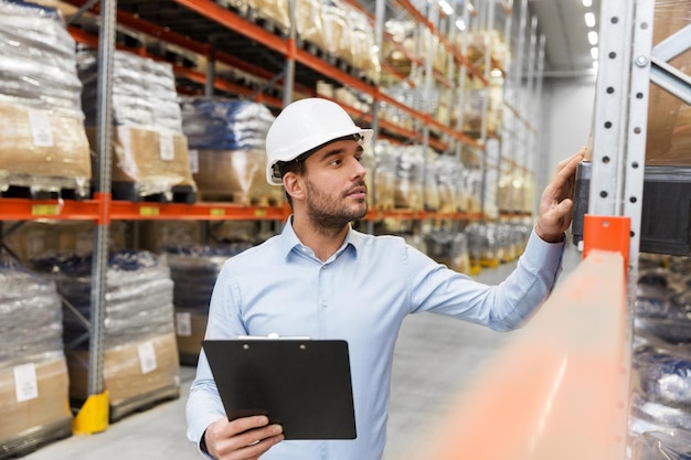 Geschäftsmann mit Helm und Clipboard im Lager