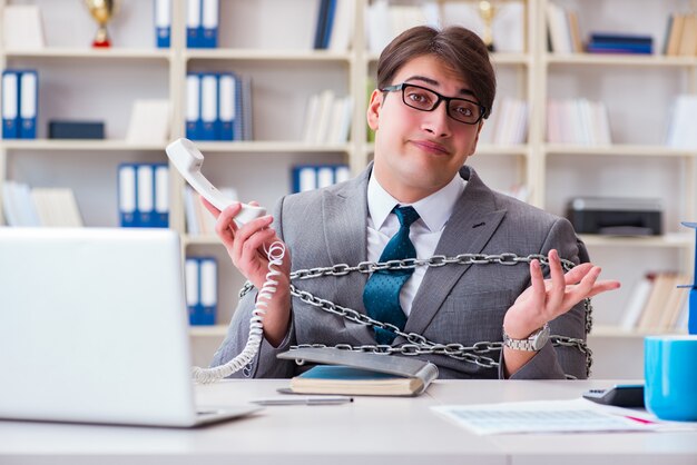 Foto geschäftsmann mit ketten an seine arbeit gebunden