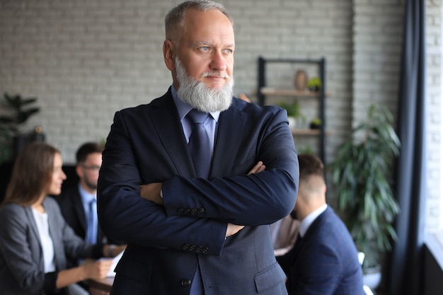 Geschäftsmann mit Kollegen im Hintergrund im Büro.