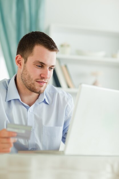 Geschäftsmann mit Kreditkarte und Laptop in seinem homeoffice