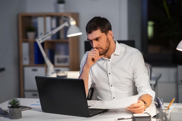 Geschäftsmann mit Laptop arbeitet in einem Nachtbüro