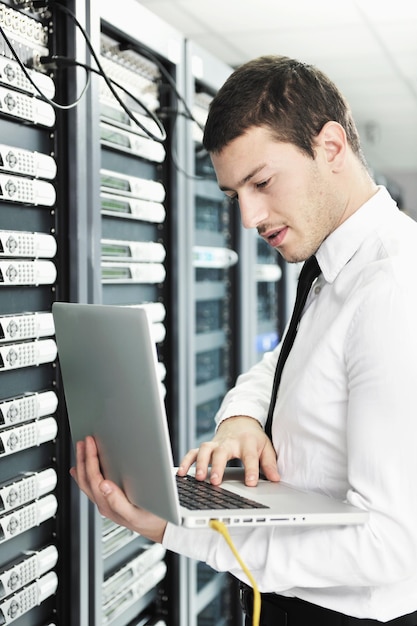 Geschäftsmann mit Laptop im Netzwerk-Serverraum
