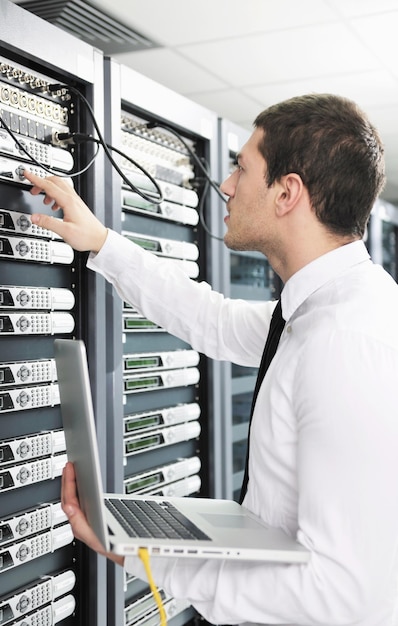 Geschäftsmann mit Laptop im Netzwerk-Serverraum