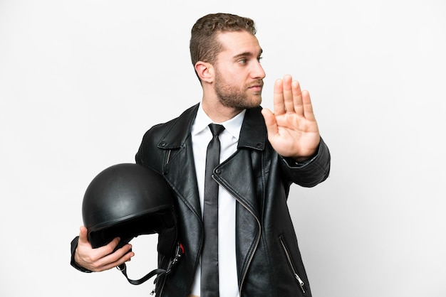 Geschäftsmann mit Motorradhelm vor isoliertem weißem Hintergrund macht Stoppgeste und ist enttäuscht