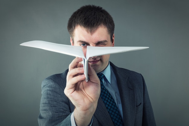 Geschäftsmann mit Papierflugzeug im Studio