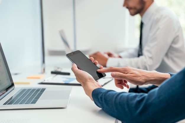 Geschäftsmann mit seinem Smartphone im Büro