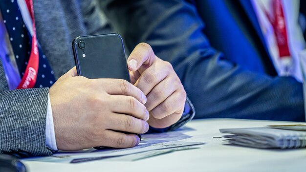 Geschäftsmann mit smartphone auf der messe