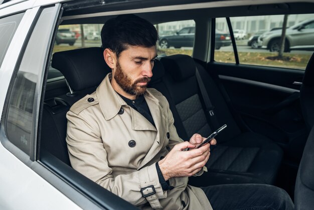 Geschäftsmann mit Smartphone im Taxi