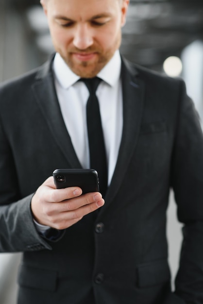 Geschäftsmann mit Smartphone im überdachten Gehweg