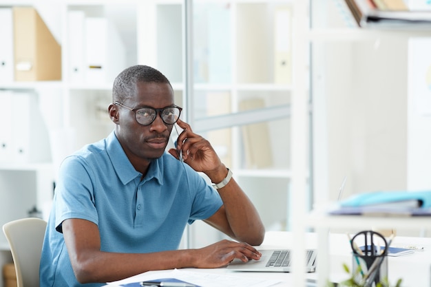 Geschäftsmann mit Telefon und Laptop bei der Arbeit