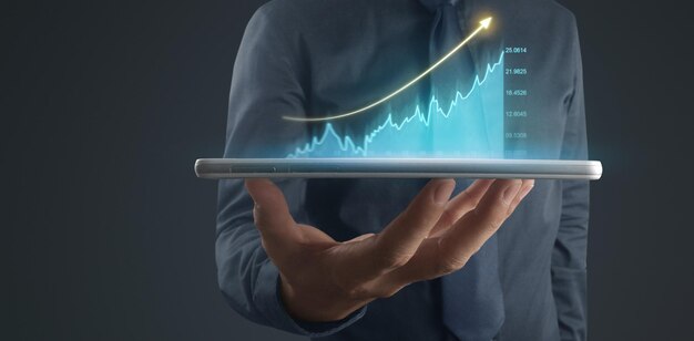 Geschäftsmann plant das Wachstum des Diagramms und die Erhöhung der positiven Diagrammindikatoren in seinem Businesstablet in der Hand