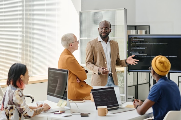 Geschäftsmann präsentiert Projekt für Programmierer im Büro