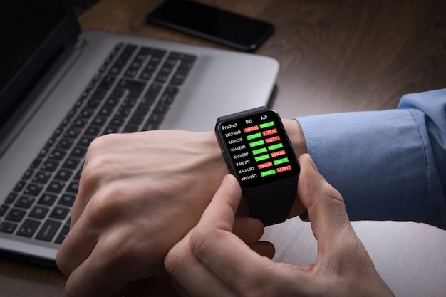 Geschäftsmann prüft Devisenhandel, Börsenkurs von Smartwatch. Die Fintech-Intelligence-Technologie ermöglicht dem Benutzer eine flexible und digitale Lösung für Finanzinvestitionen im Börsenhandel.