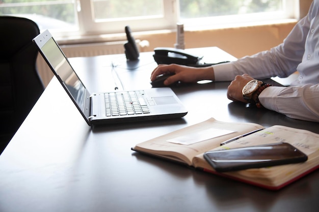 Geschäftsmann sitzt im modernen Büro und arbeitet an seinem Laptop