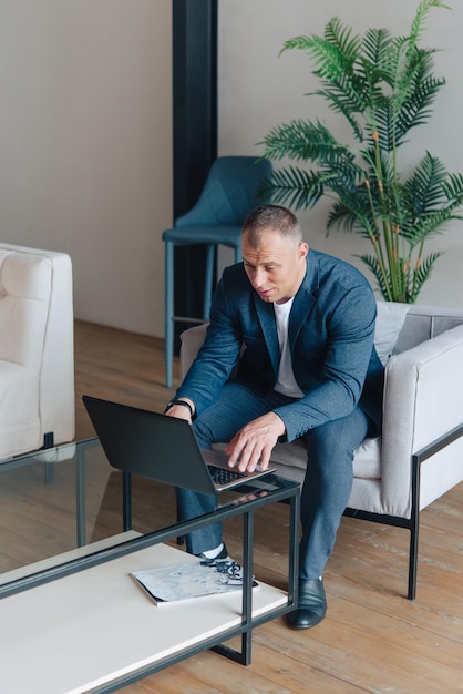 Geschäftsmann sitzt in einem Büro und arbeitet mit einem Laptop-Computer. Geschäftsmann Porträt.