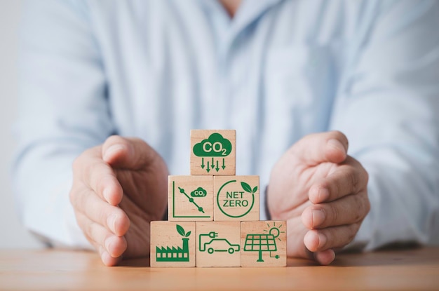 Geschäftsmann stapelt CO2-reduzierendes Recycle Green Factory-Symbol zur Verringerung des CO2-Fußabdrucks und der Kohlenstoffgutschrift zur Begrenzung der globalen Erwärmung durch den Klimawandel Bio Circular Green Economy-Konzept