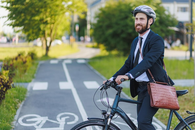 Foto geschäftsmann steht auf radweg mit fahrrad und macht sich startklar