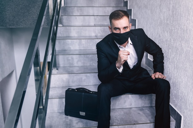 Geschäftsmann tragen Gesichtsmaske sitzen auf Treppen