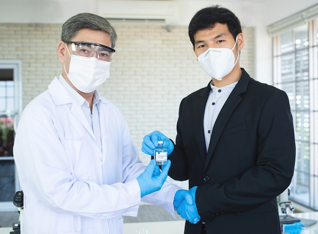 Foto geschäftsmann und arzt händeschütteln für vereinbarung covid19 impfstoff in der hand.