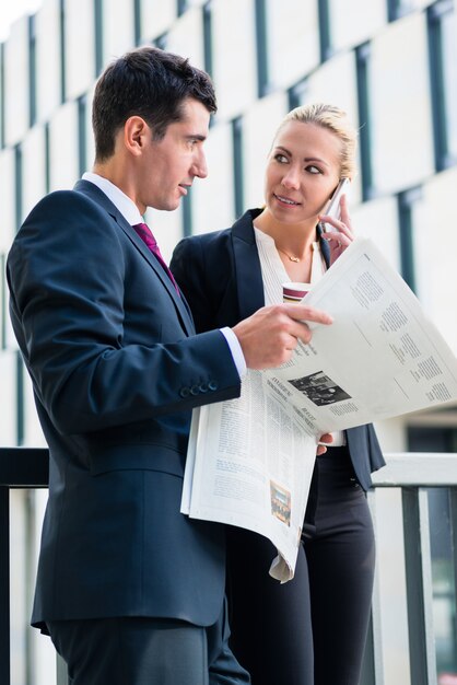 Geschäftsmann und Frau mit Papier und Telefon