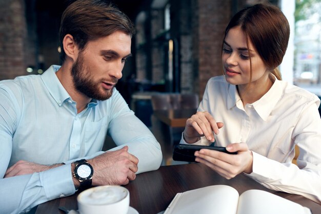 Geschäftsmann und Frau sehen sich die Arbeitskollegen der Telefonkommunikation an